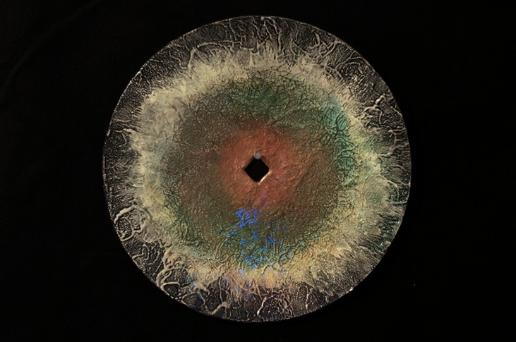 Drew Wood, Insomnia 5, 2007, phosphorus, color-shifting enamel, acrylic, garnet, and synthetic resin on a found concave iron plow disc from a Missouri farm, 8" radius